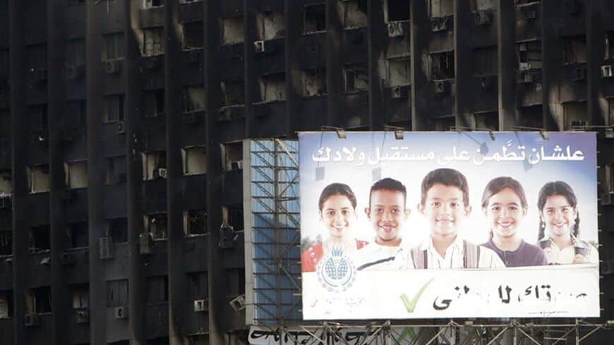 A National Democratic Party (NDP) sign is seen in front of their burned headquarters in downtown Cairo January 31, 2011. Protesters intensified their campaign on Monday to force Egypt's President Hosni Mubarak to quit as world leaders struggled to find a solution to a crisis that has torn up the Middle East political map. The sign reads "in order to be confident about the future of your children". REUTERS/Amr Abdallah Dalsh  (EGYPT - Tags: POLITICS CIVIL UNREST) - RTXXBNJ